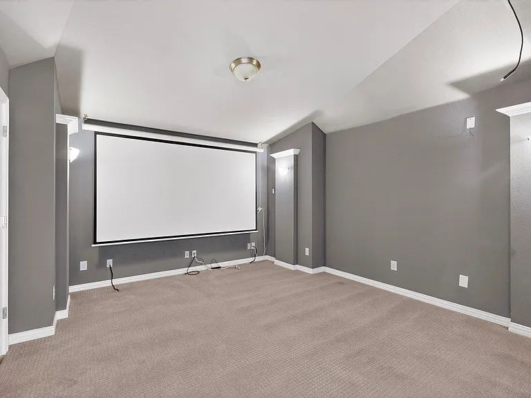 A stylish home theater setup with a projector screen, perfect for enjoying films.