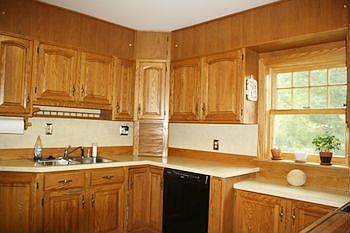 Cheerful kitchen features new window and lots of oak cupboards and countertop space.