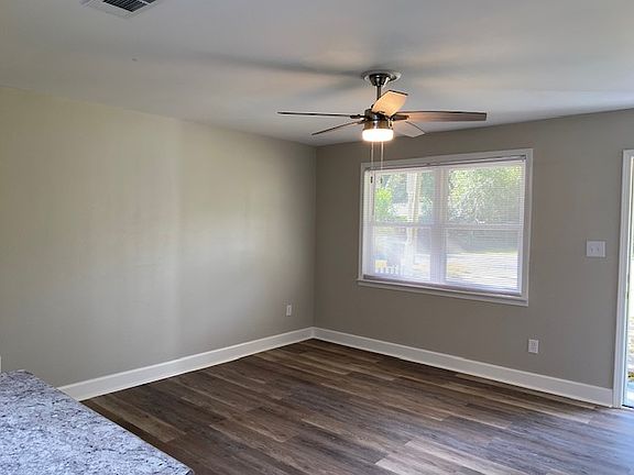 Living room with brand new flooring, coat closet, brand new ceiling fan and double window which brings in alot of sunshine.