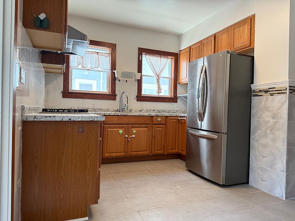 Kitchen with refrigerator, gas stove, and range hood.