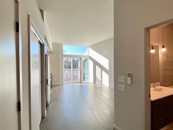Entry to studio with living area ahead, bathroom to the right, closets and washer/dryer on left.