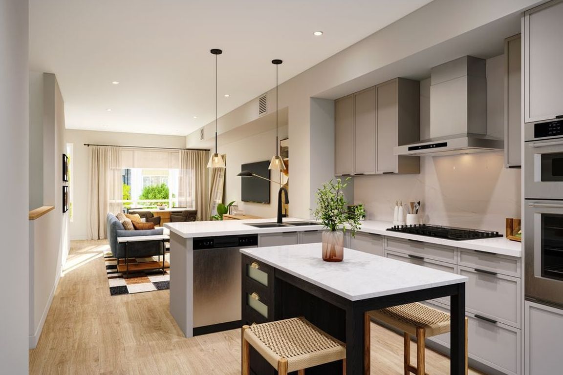 Signature Collection I 3-Bedroom Townhome kitchen with light grey cabinetry, marble quartz countertop and backsplash, upgraded stainless steel appliances, and hard-surface vinyl plank flooring throughout (Rendering)