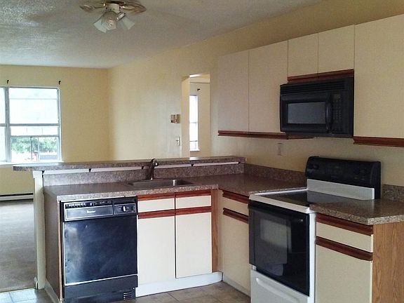Open kitchen with ceiling fan, overlooking living room.