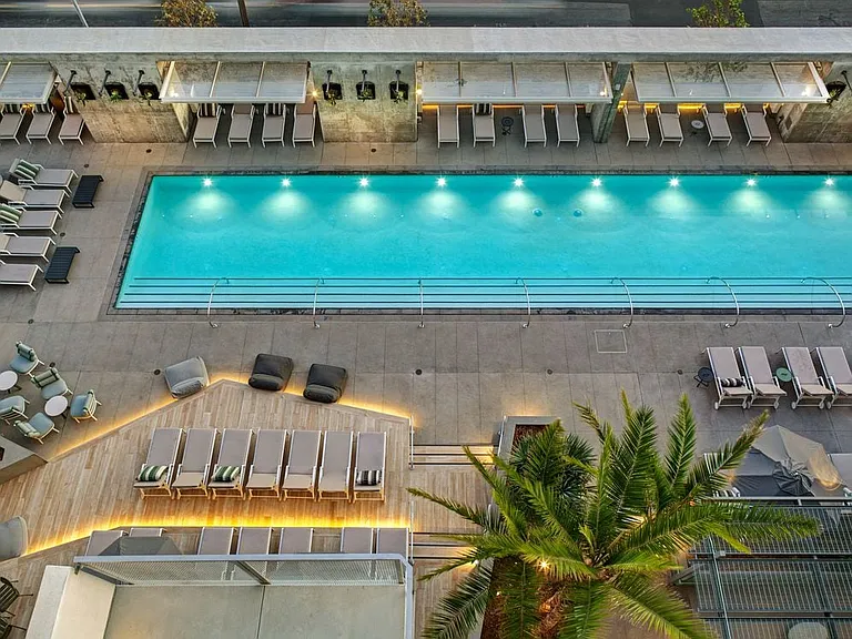 Pool and sundeck with cabanas and lounge seating