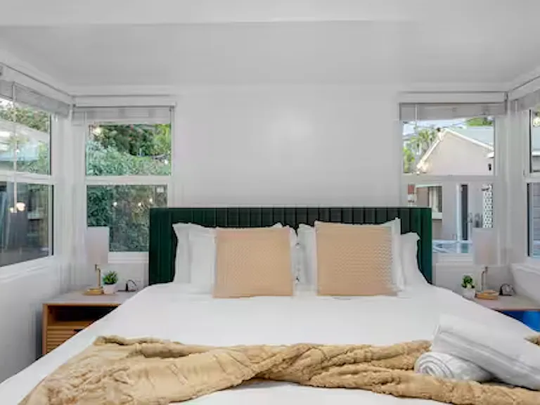 Bedroom 2 is bright and airy with windows and blackout blinds, featuring a king bed, ceiling fan, and a lampshade with extra outlet and USB ports for easy device charging. Ample closet space completes this comfortable and convenient retreat.