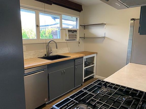 Kitchen looking into the rear yard. Butcher block counter, rolling island that can come out for prep and provides good convenient storage, gas range