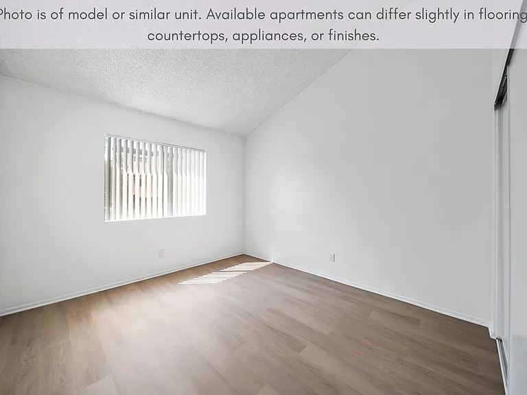 Comfortable bedroom with modern flooring and natural light.