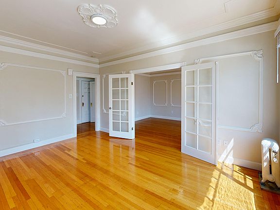 Spacious room with a wood-like flooring and a large window offering natural light