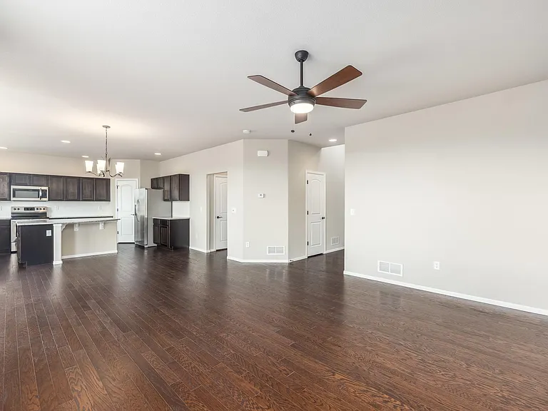 Living Room w/ Dining Area & Kitchen in background to the left, Garage Door and 1/2 bath to the right