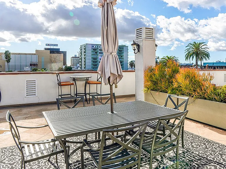 Open air rooftop patio with gas firepit, BBQs, several seating locations, and cable television.