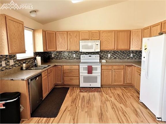 Spacious kitchen with lots of cabinets, counters, double oven, and pantry