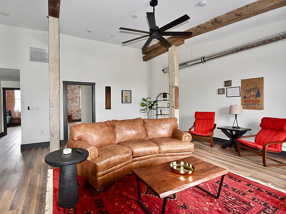 Furnished living room has a desk/work space and a smart TV. The room features ceiling spotlights that are dimmable and a ceiling fan.