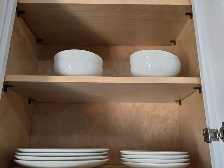 Kitchen stocked with deep plates, flat plates, and cups