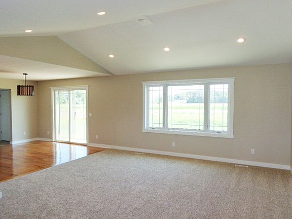 Living room with vaulted ceiling open to dining area. Dining area with Beautiful hardwood floors. Sliding glass door in dining area with easy access to the patio and backyard.