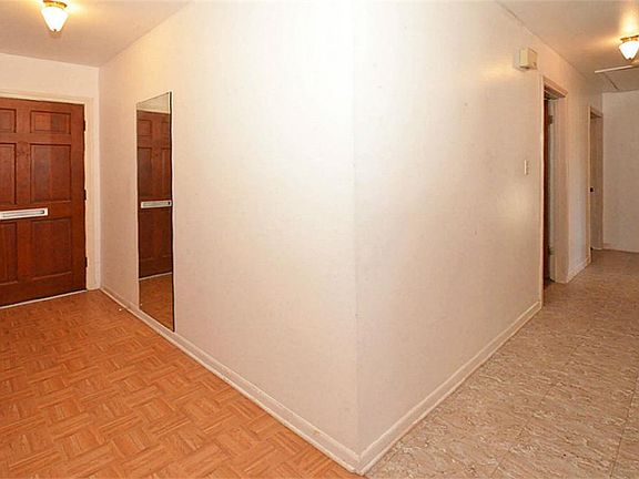 The entry door is solid wood! This view shows the foyer and the hallway to the bedrooms and bathrooms.