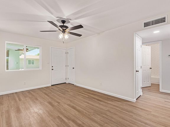 Looking from kitchen towards front door. On the right is the hall storage and the open door is the bathroom. One bedroom is down the hall on the left and the other is on the right.