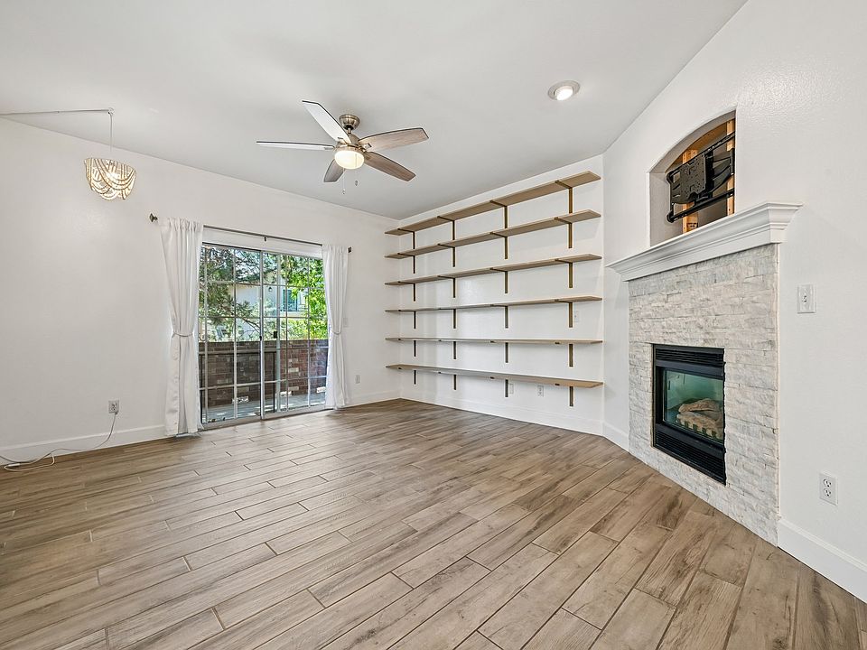 Living room, with gas fireplace, deck access and floor to ceiling bookshelves.