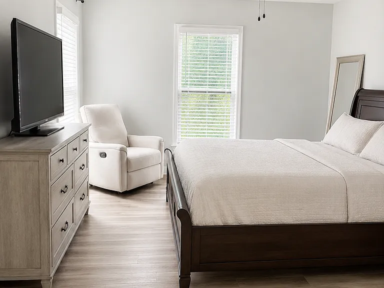 Spacious primary bedroom with ceiling fan and walk in closet. Room currently furnished, but will be cleared out before move-in.