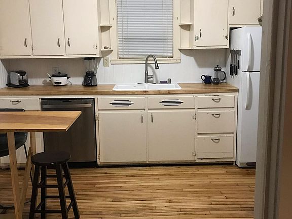 Newly remodeled kitchen with hardwood floors, butcherblock countertops, Kohler cast iron sink, and stainless steel dishwasher.