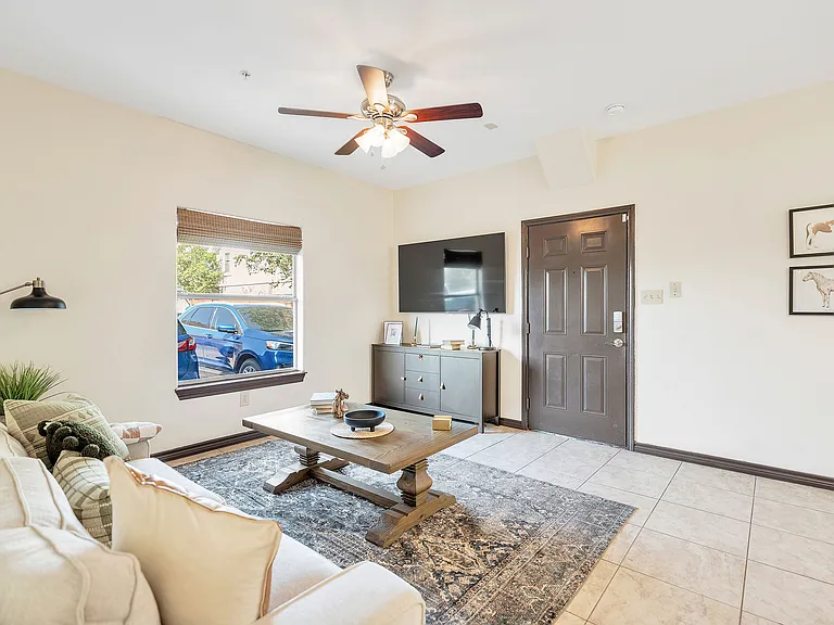Interior of a La Joya Apartments living room in Laredo, Texas, showcasing a ceiling fan and a television