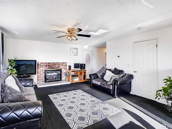 Living room bright and has a wood burning fireplace. Side door leads to half bath, W/D, and hot water tank.