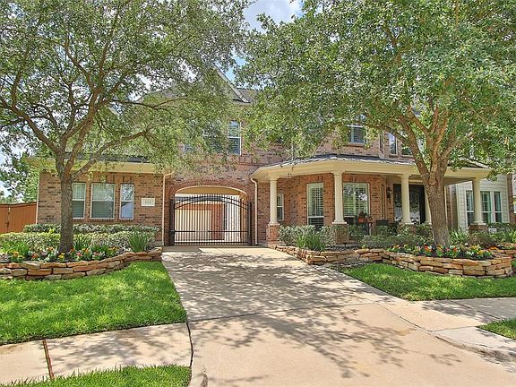 Gated motor court to two car garage and detached one car garage. Beautiful, mature trees and raised landscaped beds. Full brick exterior.