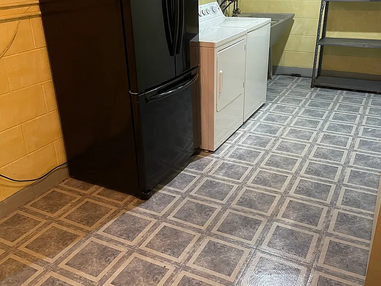 Large laundry with second refrigerator and extra storage area.