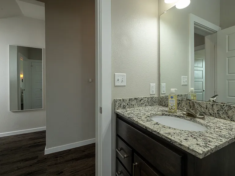 Bathroom 3 has a tub/shower combo and granite cabinet sink with mirror. This bathroom is located upstairs.