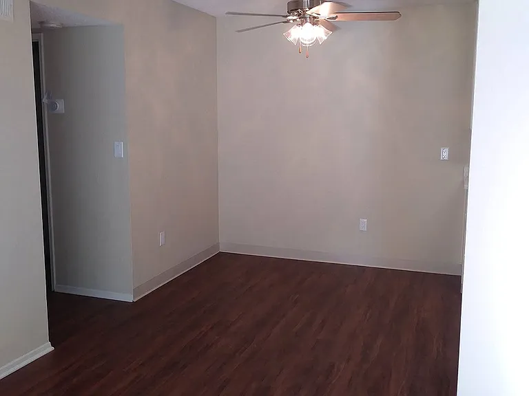 Dining room with ceiling fan and dark hardwood flooring at Teton Pines Apartments in Escondido, California.
