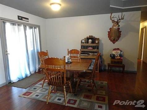 Dining area with laminate flooring and door leading on to deck.