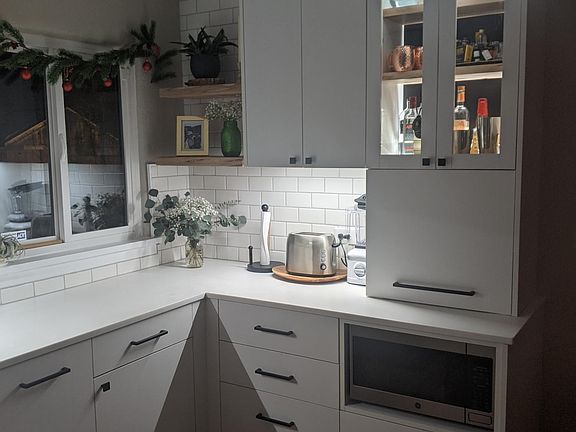 Same view of the kitchen, at night. Note the under cabinet lighting, built-in lit-up bar, countertop appliance garage, and hidden microwave.