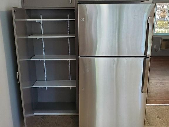 Pantry and new stainless-steel 22 cu. ft. GE refrigerator.
