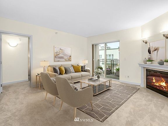 Open floor plan with spacious living room with electric fireplace that cranks out the heat and slider to covered deck. Virtually staged to give design idea.