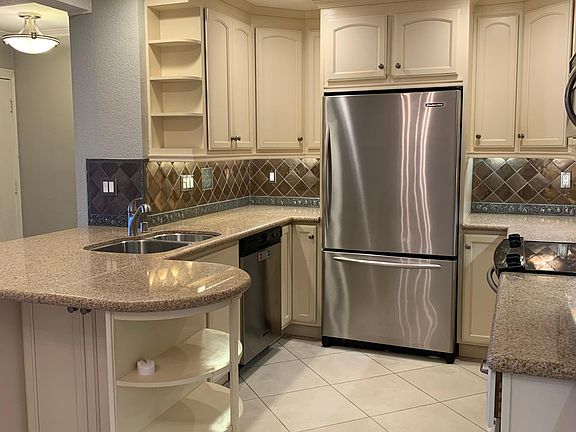 Kitchen with plenty of shelves and cabinets, and even room for barstools