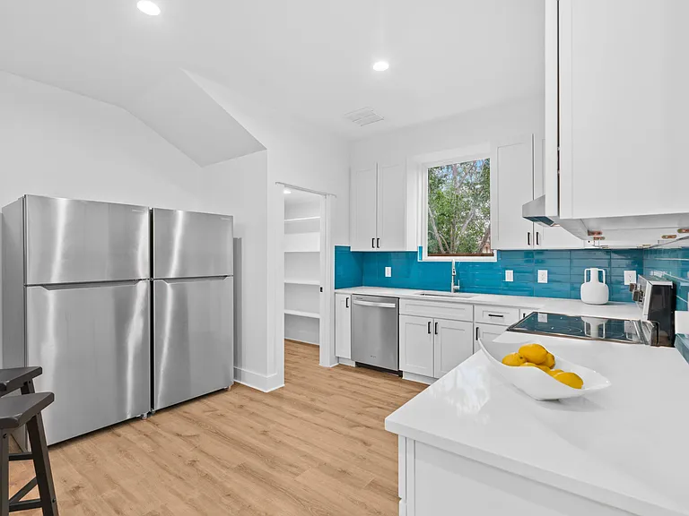 Updated kitchen with stainless-steel appliances, generous cabinet storage, and a large window over the sink.