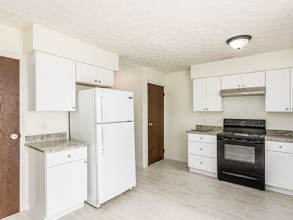 Kitchen with tile floor, granite countertops and backsplash, new cabinets, and new appliances