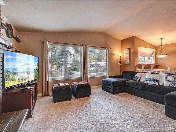 The living room offers vaulted ceilings and large windows to bring in natural light.