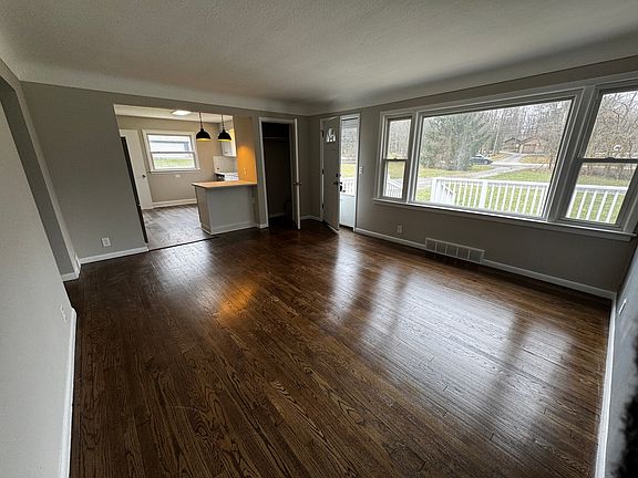 Large living room with newly refinished hardwood floors and lots of natural light from the picture window