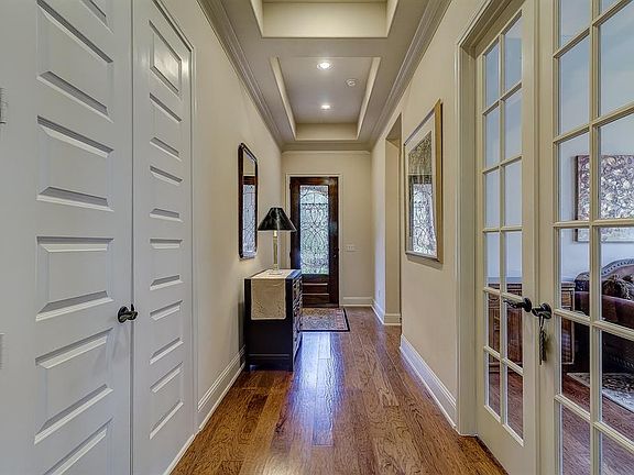 As you enter the home, notice the stunning wood floors and tray ceilings. Each room includes 9' panel doors and includes plantation shutters across the front of this lovely home.