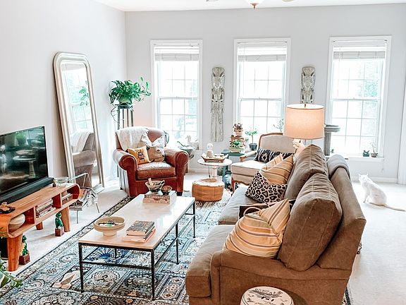 Open concept living room on 2nd floor. Featuring 3 windows and 1/2 bathroom on the right