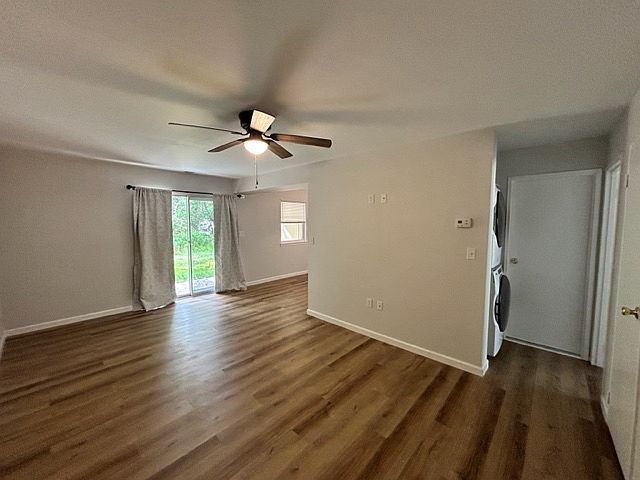 Looking from end of hallway into the condo to the sliding glass door and into the breakfast nook. Notice the new stackable washer and dryer on the left . Door on the right leads into the bathroom. Ceiling fan and light. Full wall is wired for flatscreen