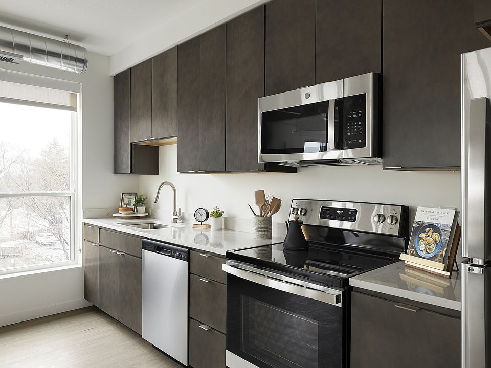 Rich cabinets, quartz counters, and modern fixtures complete this perfect and efficient kitchen setup