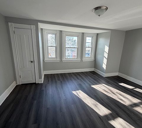Spacious front bedroom with triple window and lots of space.