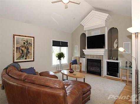 Warm and inviting family room with gas fireplace, decorative niches, cathedral ceilings, & gleaming hardwood floors.