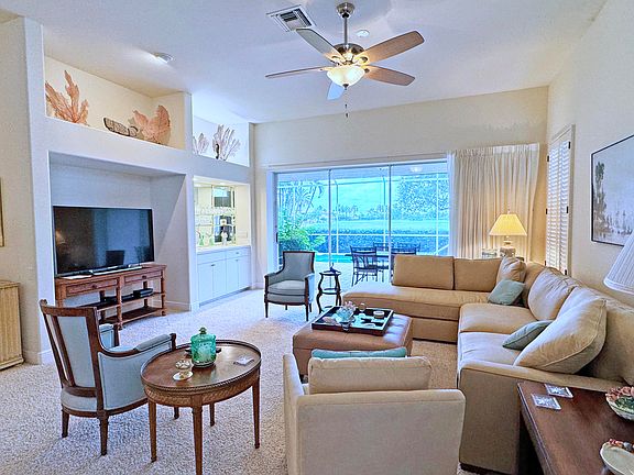 The living room has a large 60" smart TV, wet bar and ceiling fan. The wide sliding doors can open all the way to a 12' width.