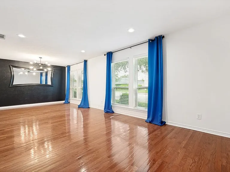Spacious room featuring polished wood-finish flooring