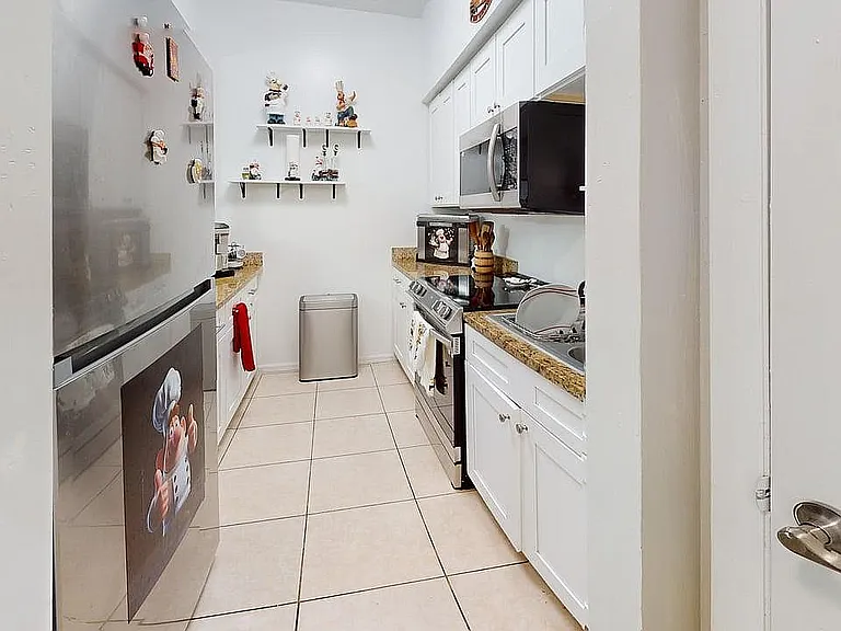 Charming modern kitchen with sleek stainless steel appliances, white cabinets, and inviting granite countertops.