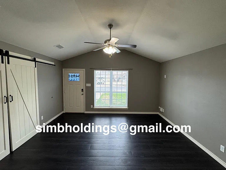 Living room with bonus room through the barn doors on the side