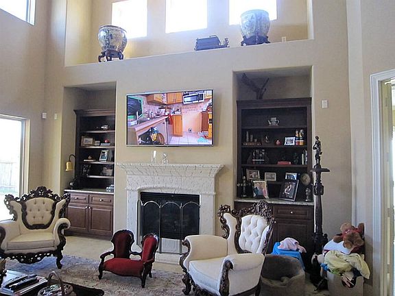 This beautiful two-story family room includes built-ins to store family photos. Fireplace adds a cozy note to the room