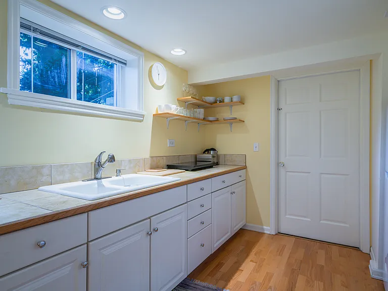 Kitchen with 2 burner cooktop, microwave, toaster, electric kettle and fridge